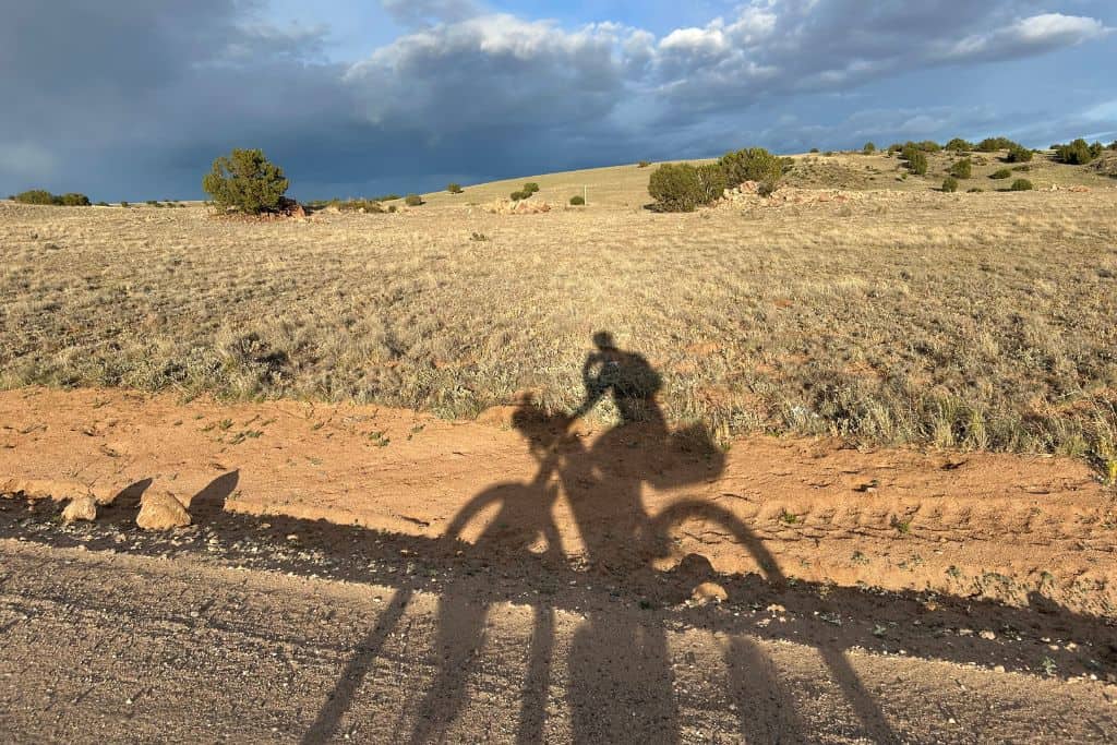 Bicycle shadow with rider on roadside