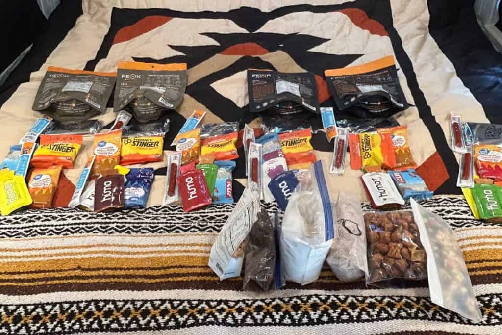 Cycling food laid out on bed in camper van