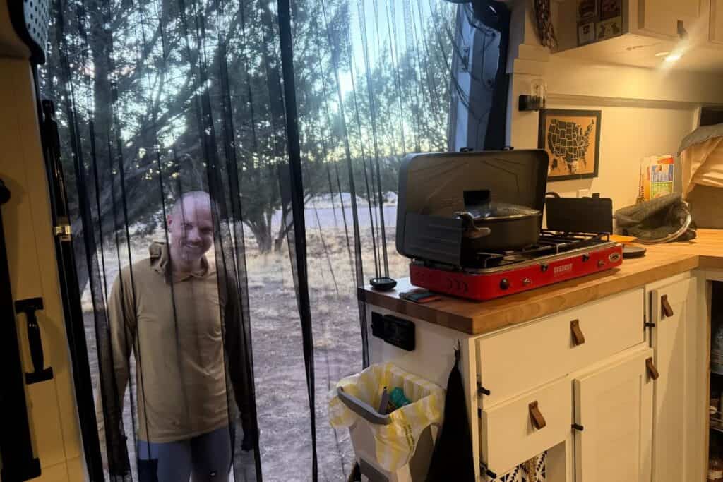 Cyclist outside bug screen in camper van