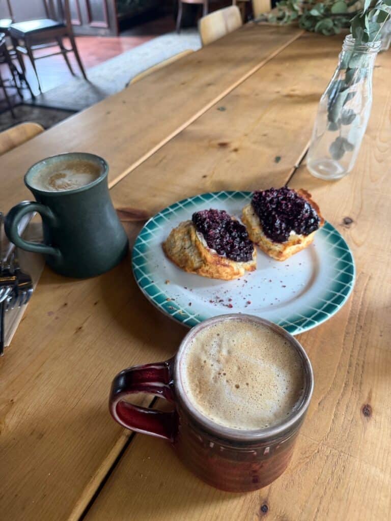 Lattes on rough wooden table with blueberry biscuits